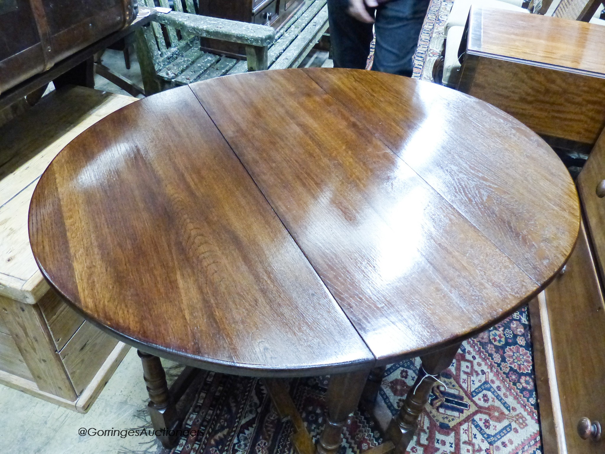 An 18th century style oval oak gateleg table, 100cm extended, depth 83cm, height 74cm